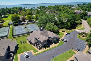 A residential area with a large house, a tennis court, and a parking lot.