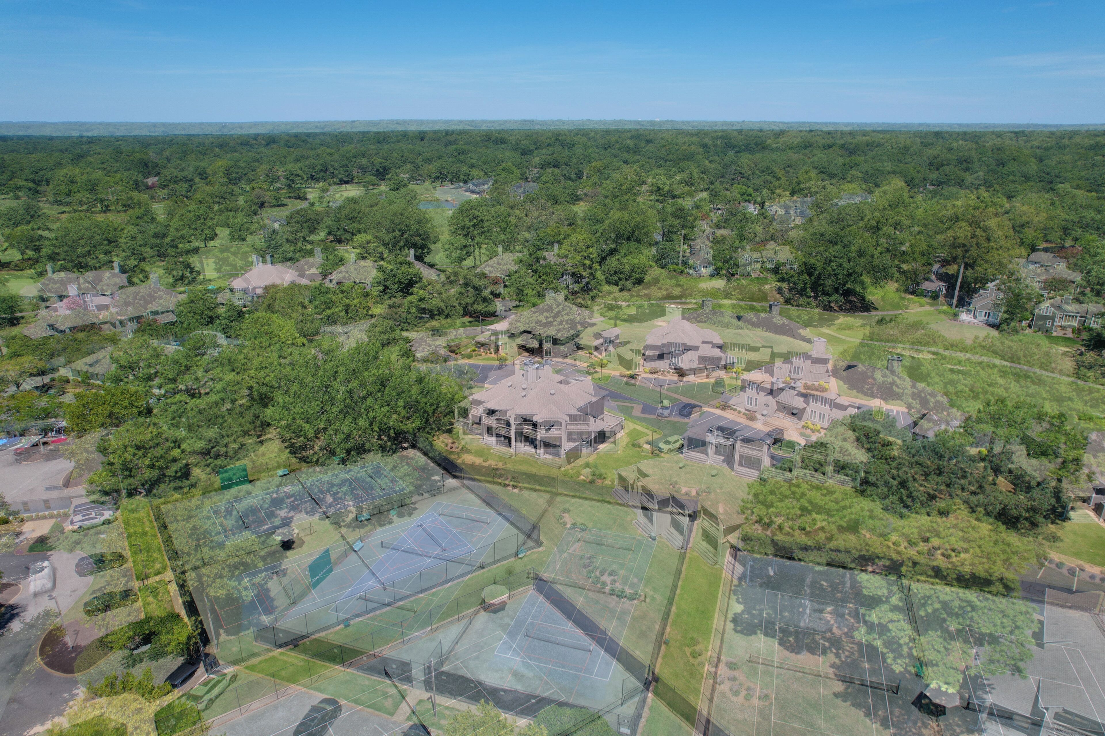 Une vue aérienne d’un quartier résidentiel avec de nombreuses maisons, des espaces verts et un grand terrain de sport.