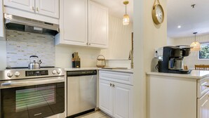 A modern kitchen with stainless steel appliances, white cabinetry, and a coffee machine. - Relax, Recharge, Repeat: Hilton Head Resort Condo (Hilton Head Island)