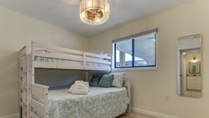 A bedroom with bunk beds, a window, a mirror, and a ceiling light fixture. - Relax, Recharge, Repeat: Hilton Head Resort Condo (Hilton Head Island)