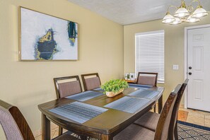 A dining area with a wooden table, blue placemats, and a potted plant. - Centrally Located Escape in Midvale w/ Yard! (Midvale)
