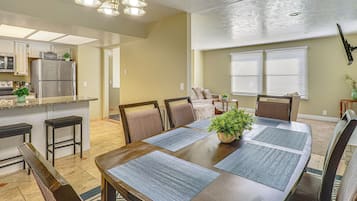 Comedor con una mesa de madera, sillas y una planta en el centro.