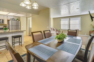 Comedor con una mesa de madera, sillas y una planta en el centro.