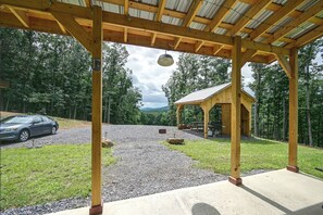 Un espace extérieur abrité, avec un chemin de gravier, une table de pique-nique et une petite structure en bois.