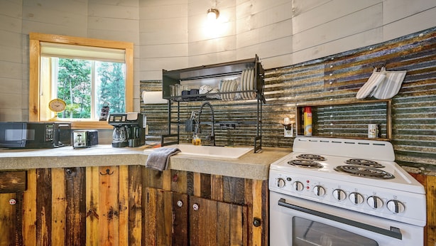 A kitchen with wooden cabinets, a stove, a microwave, and a coffee maker. - Outdoor Oasis w/ Mtn Views! 5-acre Augusta Getaway (Augusta)