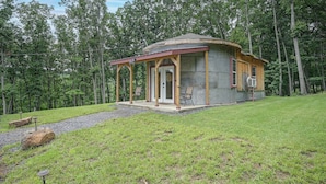 A small, single-story cabin with a porch, surrounded by a grassy area and trees. - Outdoor Oasis w/ Mtn Views! 5-acre Augusta Getaway (Augusta)