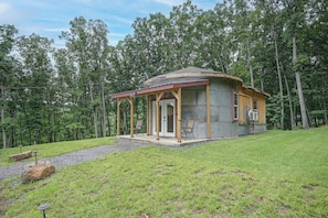 A small, single-story cabin with a porch, surrounded by a grassy area and trees. - Outdoor Oasis w/ Mtn Views! 5-acre Augusta Getaway (Augusta)