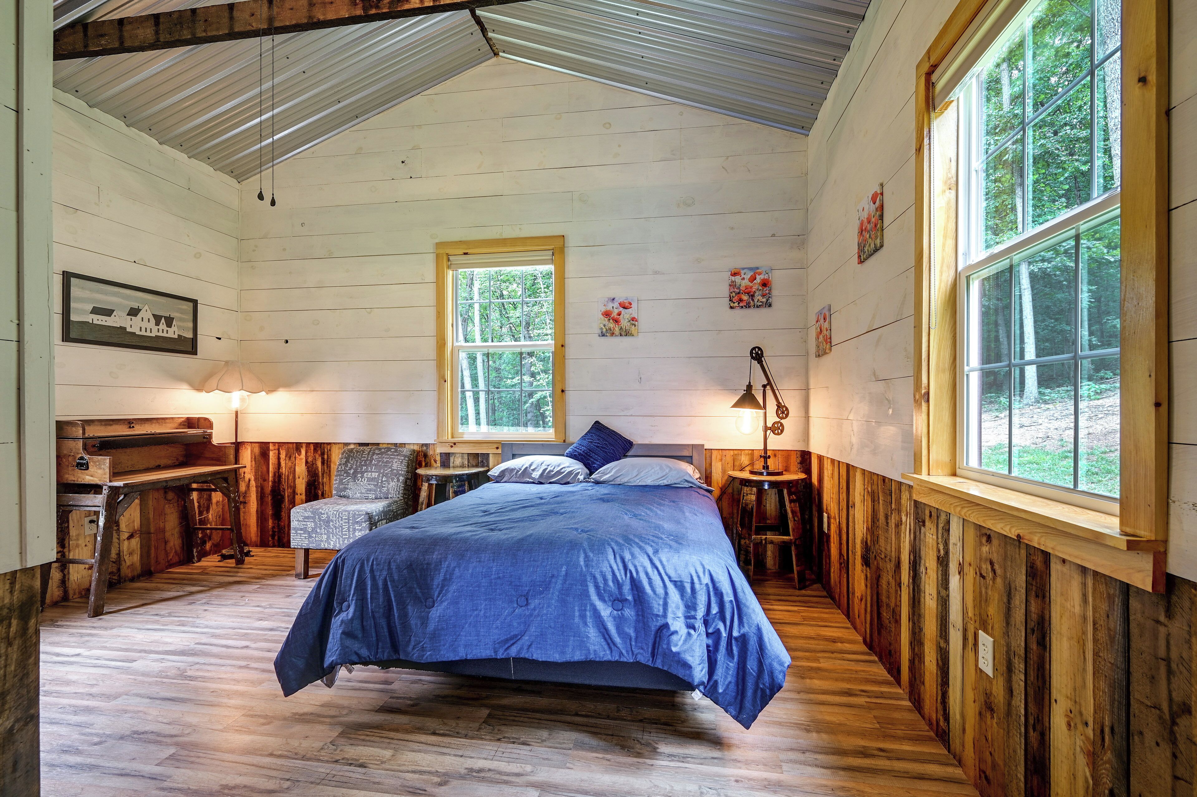 Une chambre à coucher avec un lit, un bureau, une chaise et une fenêtre.
