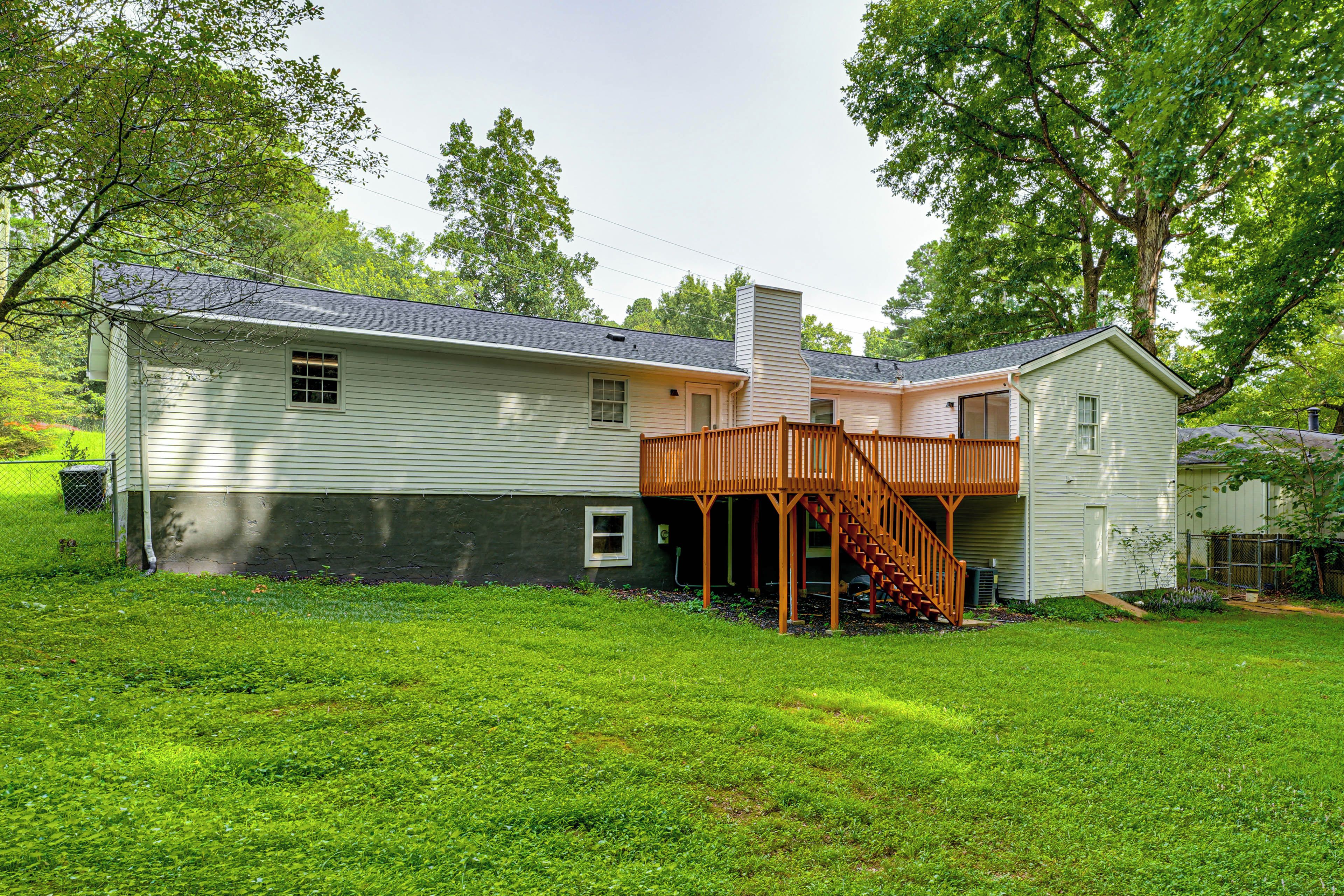 A two-story house with a covered patio and a fenced yard.
