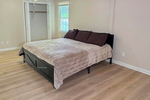 A bedroom with a bed, a closet, and a window.