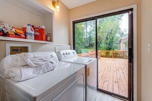 A laundry area with a washing machine, a dryer, and a shelf with cleaning supplies.