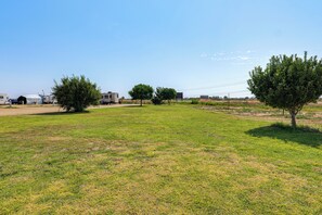 A grassy field with trees and a clear sky. - Hot Tub & Mtn Views! Carlsbad RV Retreat (Carlsbad)