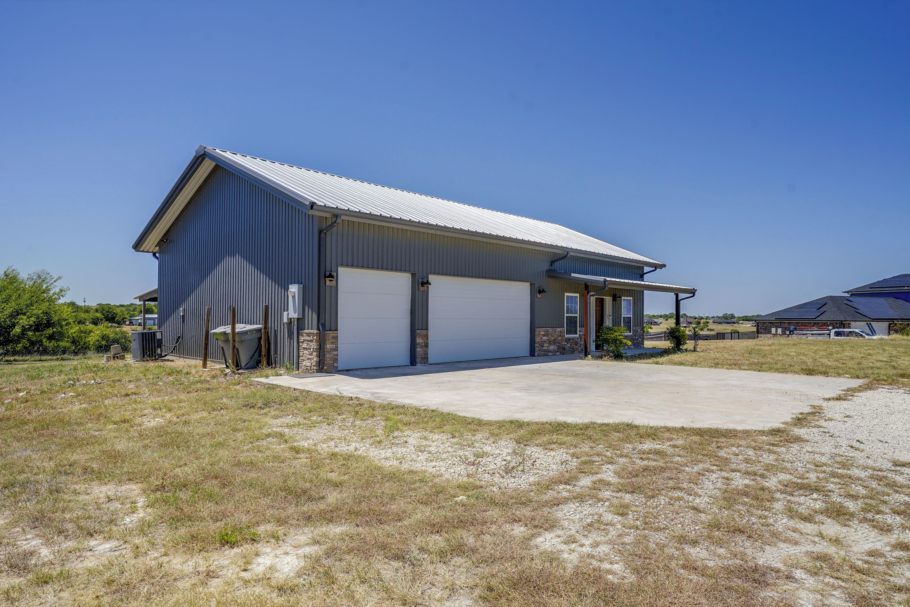 A single-story industrial building with a metal roof and two large garage doors.