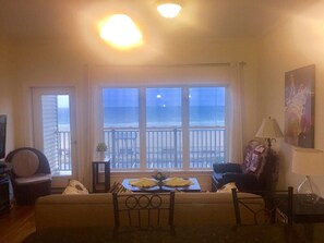 Ein Wohnzimmer mit Meerblick, einer Couch, einem Tisch mit einer Schale und einer Lampe.