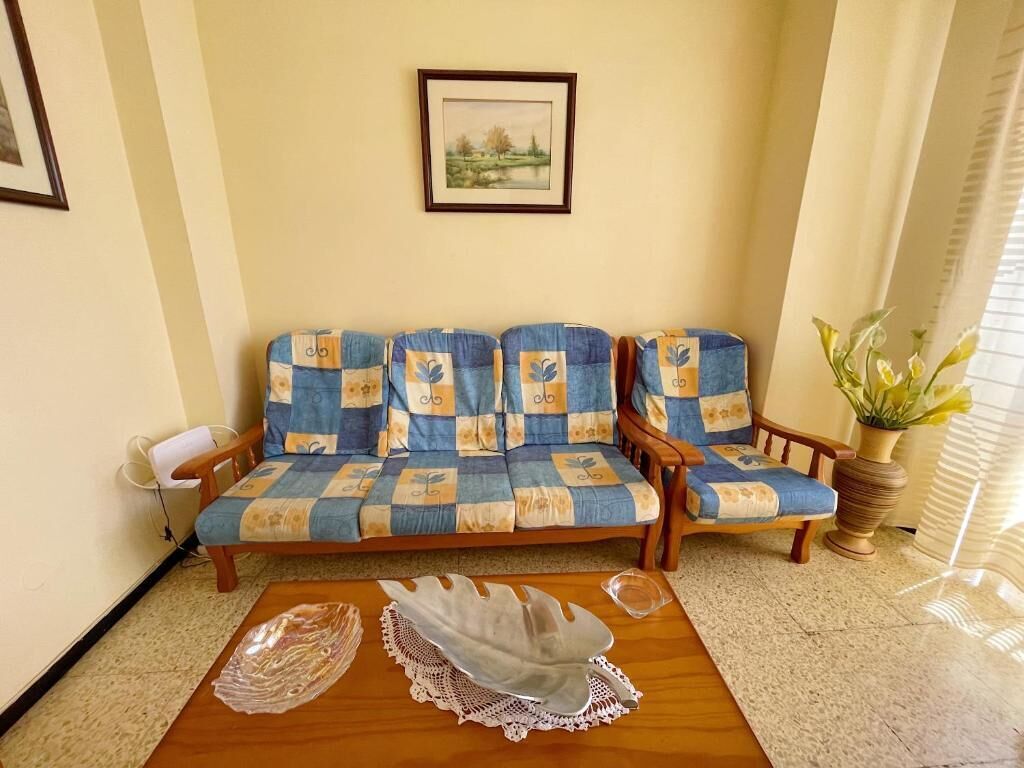Una sala de estar con un conjunto de sofás, una mesa de centro y un cuadro en la pared.