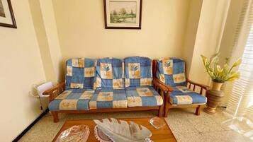 Una sala de estar con un conjunto de sofás, una mesa de centro y un cuadro en la pared.