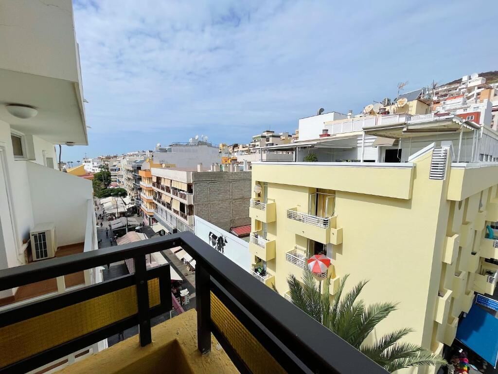 Un barrio residencial con varios edificios, balcones y cielo despejado.