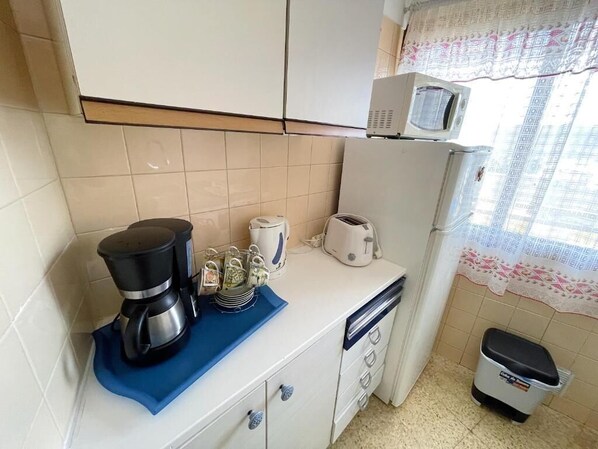 A kitchen with a coffee maker, toaster, and microwave on the counter. - Edificio Sierra (Arona)