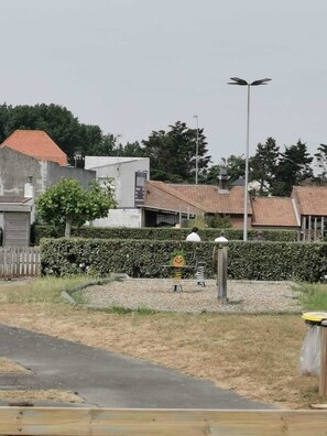 Zona residencial amb carrer pavimentat, una tanca i un fanal.
