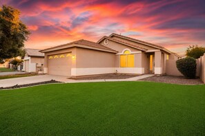 A residential house with a garage, a well-maintained lawn, and a driveway. - Spacious 3BR Home with Study & Large Backyard (Gilbert)