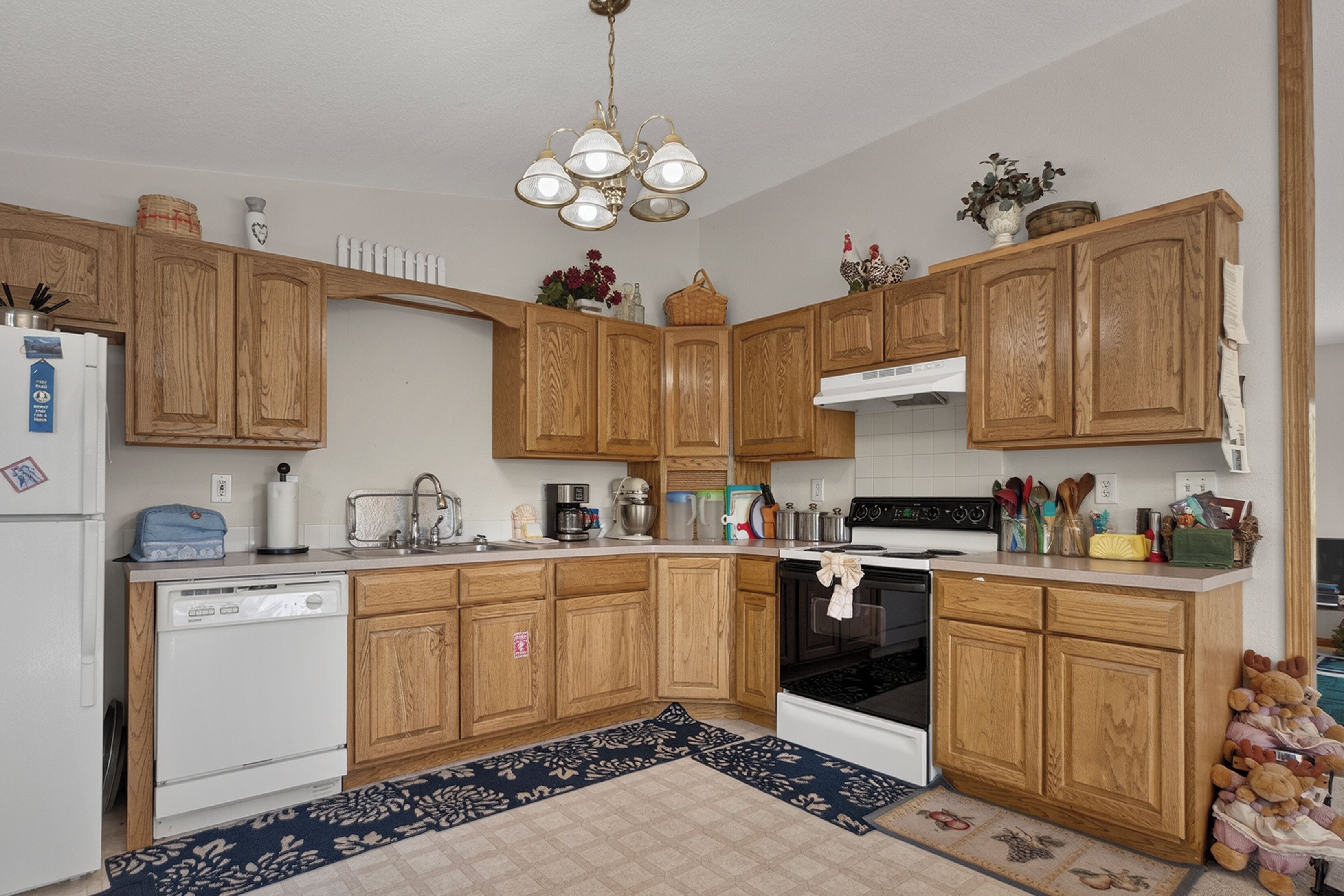 A kitchen with wooden cabinets, a dishwasher, a stove, and various kitchen appliances.
