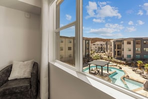 A room with a view of a pool and buildings. - Adventure Loft: Pool Views! Games! (Hurricane)
