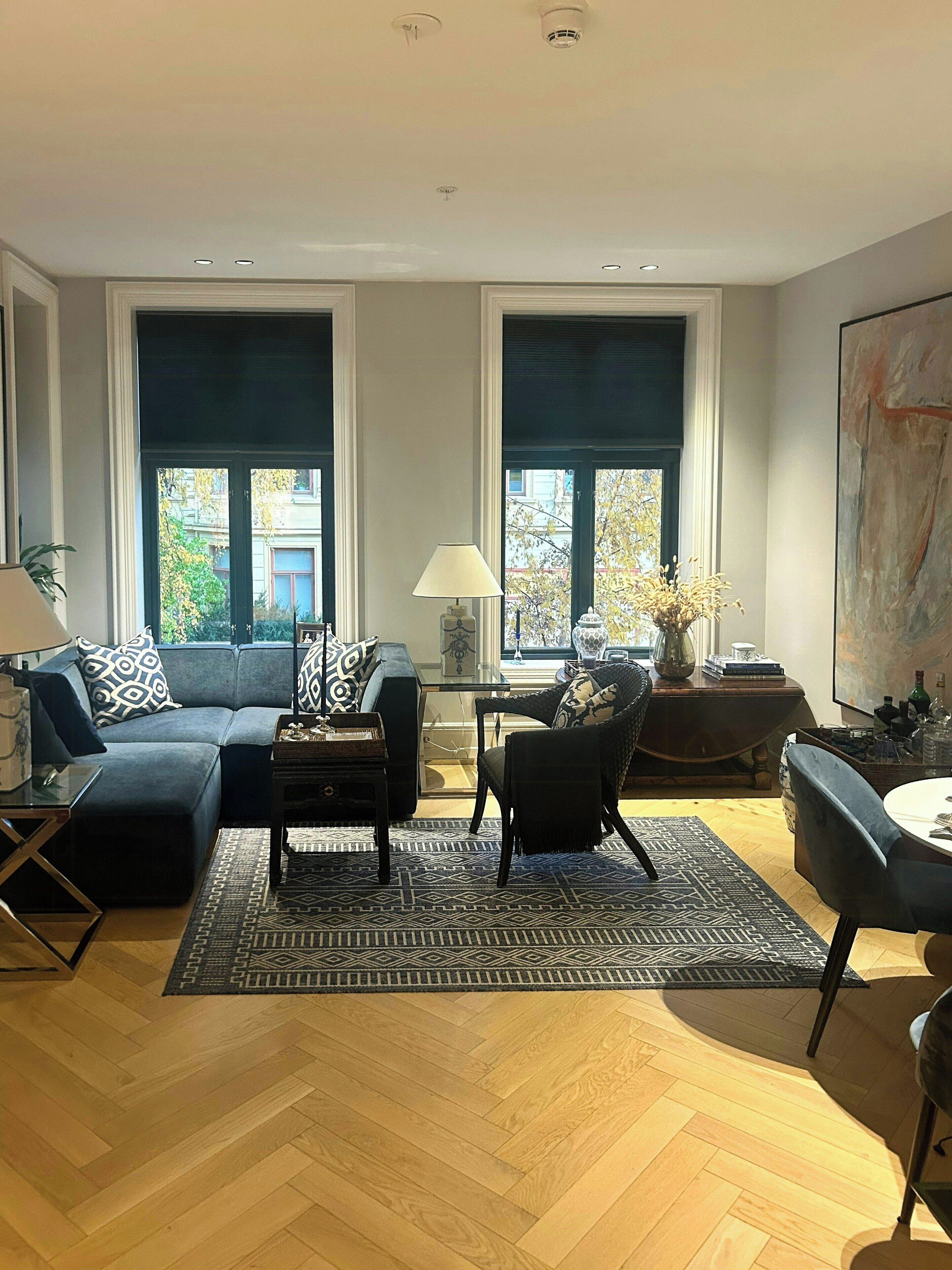 A modern living room with a sectional sofa, a coffee table, and a dining area with a chair and table.