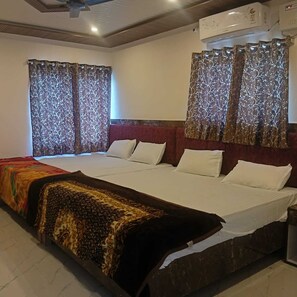 A hotel room with a large bed, two bedside tables, and curtains with a tree pattern.