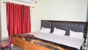 Un dormitorio con una cama de madera, cortinas rojas, una pared blanca y una ventana.