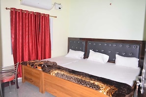 A bedroom with a wooden bed, red curtains, a white wall, and a window.