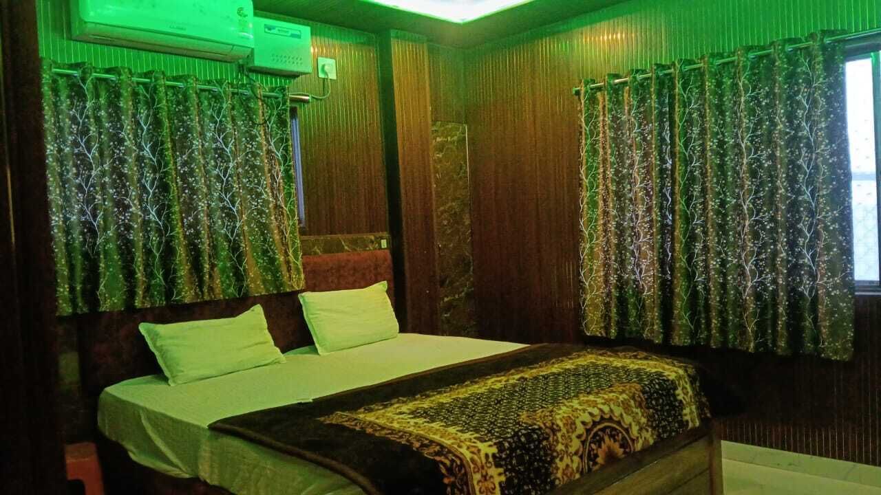 Ein Zimmer mit Bett, Vorhängen und einer Klimaanlage.