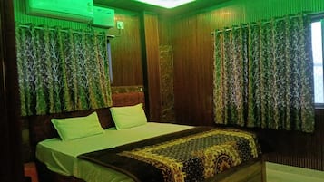 Una habitación con cama, cortinas y un equipo de aire acondicionado.