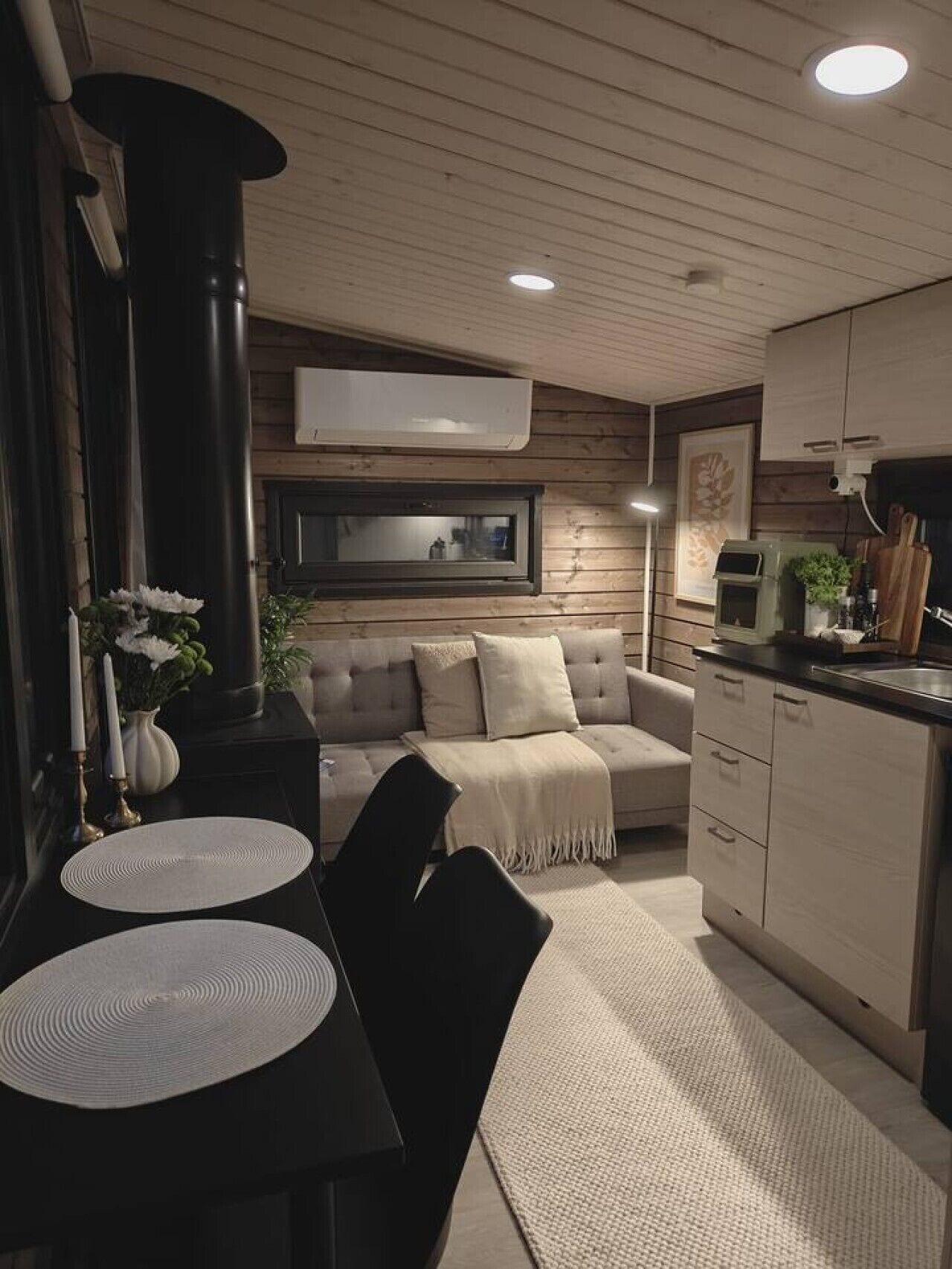 Una cocina moderna con microondas integrado, un comedor con mesa y sillas, y un sofá en la sala de estar.