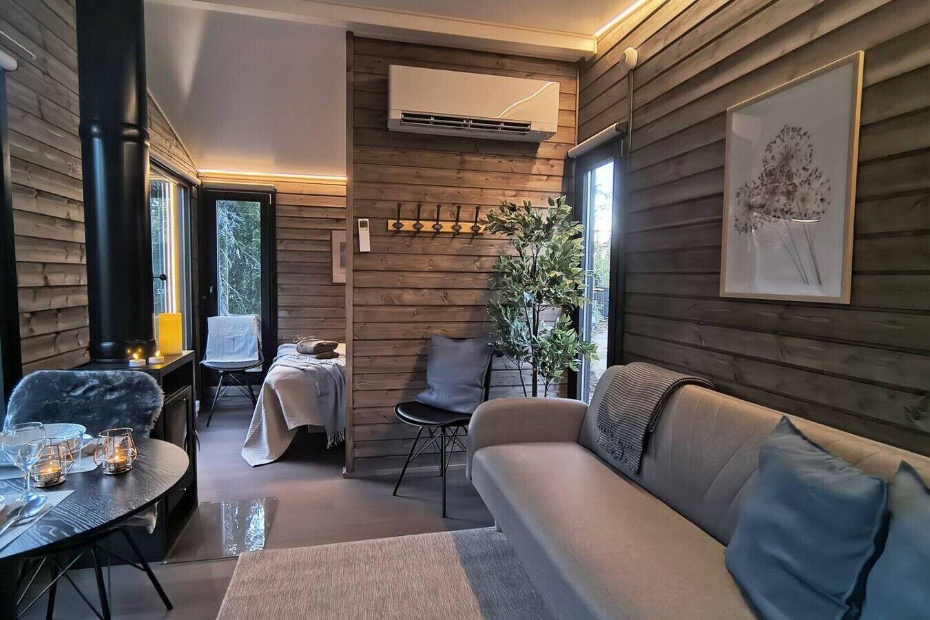 A cozy interior with a sofa, a dining table, and a fireplace.