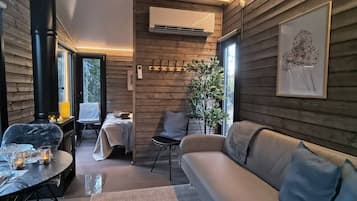 A cozy interior with a sofa, a dining table, and a fireplace.