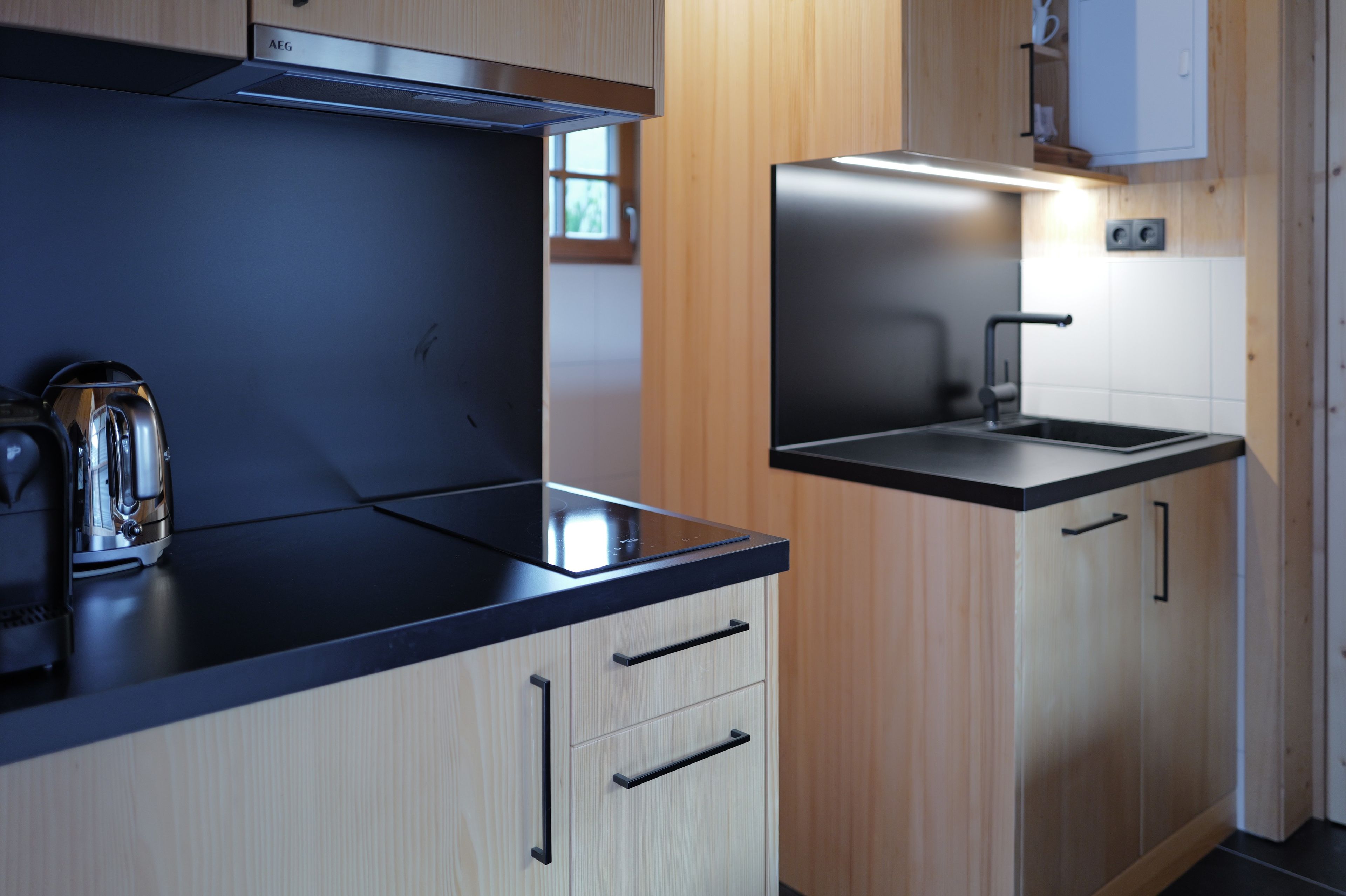 A modern kitchen with a stove, sink, and cabinets.