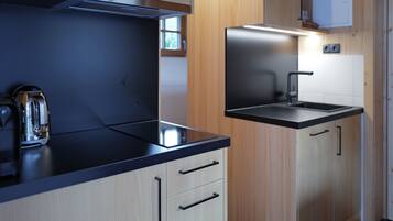 A modern kitchen with a stove, sink, and cabinets.