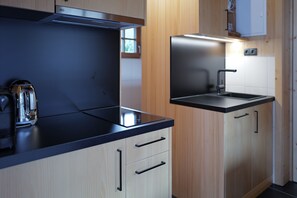 Een moderne keuken met een fornuis, gootsteen en kastjes.