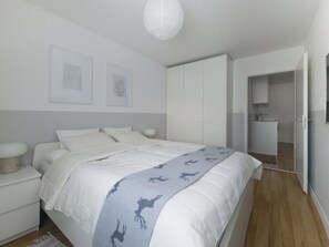 A bedroom with a bed, bedside tables, a wardrobe, and a bathroom visible through an open door. - Casa Bivio Appartement/Fewo, Bad, WC, 1 Schlafraum 2.5 - Zimmerwohnung 4 Betten by Interhome (Bivio)