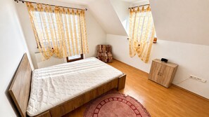 A bedroom with a bed, a wooden cabinet, and a window with curtains. - 2 room Apartment, mountains view, Stará Lesná (Stará Lesná)