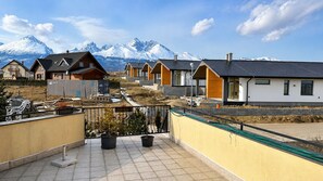 A residential area with houses, a balcony with potted plants, and a mountain backdrop. - 2 room Apartment, mountains view, Stará Lesná (Stará Lesná)