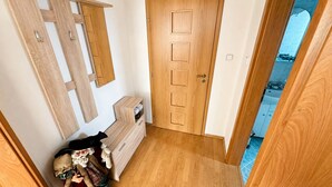A wooden door with a handle, a small wooden cabinet with drawers, and a mirror on the wall. - 2 room Apartment, mountains view, Stará Lesná (Stará Lesná)