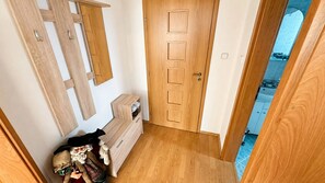 A wooden door with a handle, a small wooden cabinet with drawers, and a mirror on the wall. - 2 room Apartment, mountains view, Stará Lesná (Stará Lesná)