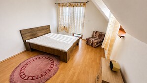 A bedroom with a bed, a chair, a radiator, and a window with curtains. - 2 room Apartment, mountains view, Stará Lesná (Stará Lesná)