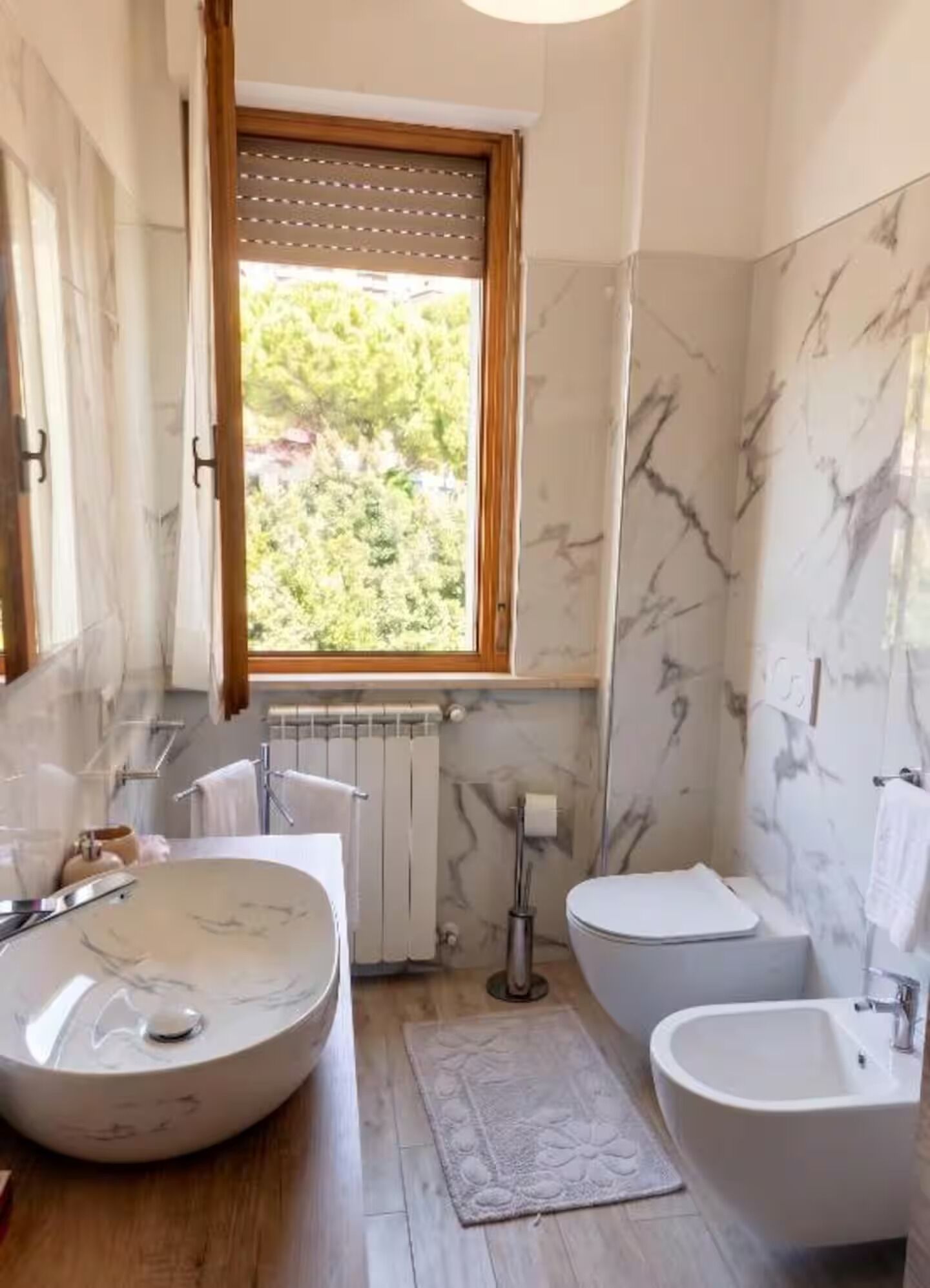 Een badkamer met een groot ovaal wastafel, toilet en bad.
