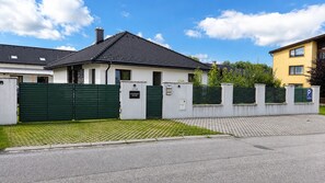 Un lotissement résidentiel fermé, avec une maison portant l’inscription « Immeuble d’appartements 110 » et un panneau indiquant un espace de stationnement.