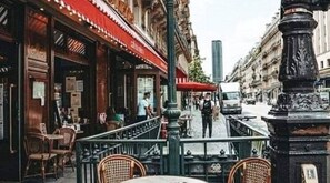 A street view with a café, outdoor seating, and a pedestrian walkway. - Parisian Opulence – Luxury Art Deco Apartment in Saint-Germain-des-Prés (Paris)