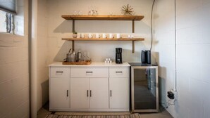 Eine Küchenzeile mit einem weißen Schrank, einer Kaffeemaschine und einer Mikrowelle.