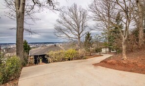 A residential driveway leading to a house with a view of a cityscape.