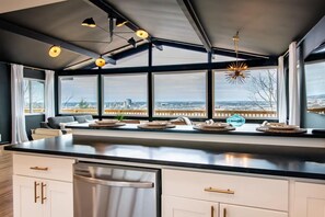 A modern kitchen with a large island, built-in appliances, and a view of the city.